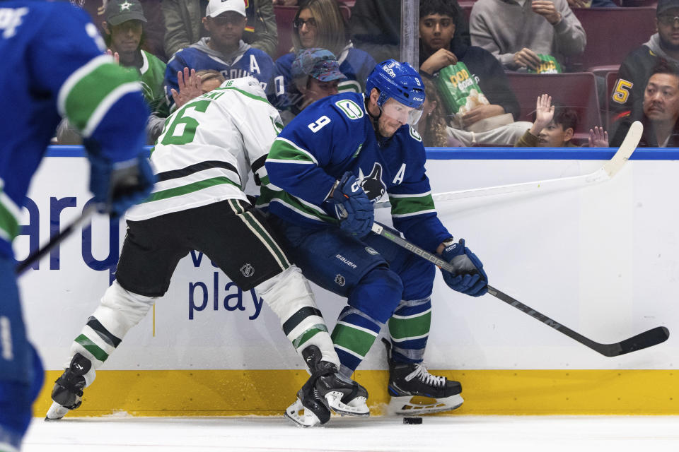 Dallas Stars' Joe Pavelski (16) and Vancouver Canucks' J.T. Miller (9) vie for the puck during the third period of an NHL hockey game Saturday, Nov. 4, 2023, in Vancouver, British Columbia. (Ethan Cairns/The Canadian Press via AP)