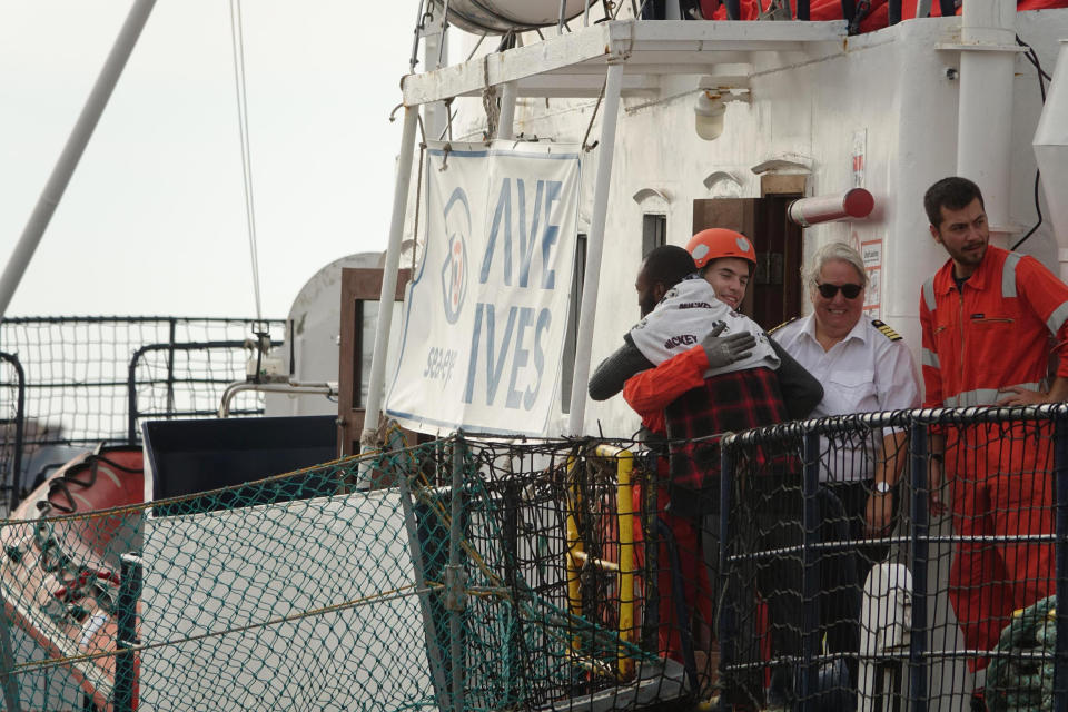 A migrant hugs a rescuer aboard the Alan Kurdi rescue ship, before stepping into the port of Taranto, Italy, Sunday, Nov. 3, 2019. He was among 88 people aboard the Alan Kurdi, a ship operated by the Germany Sea-Eye humanitarian group, rescued in the Mediterranean Sea north of Libya and disembarked Sunday in the port of Taranto. (Renato Ingenito/ANSA via AP)