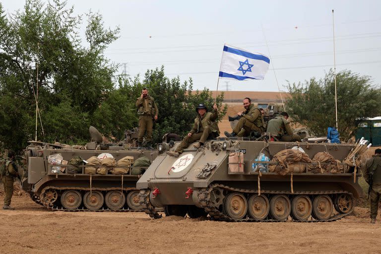 Israeli soldiers take positions in their armoured vehicles near the border with Gaza in southern Israel on October 9, 2023