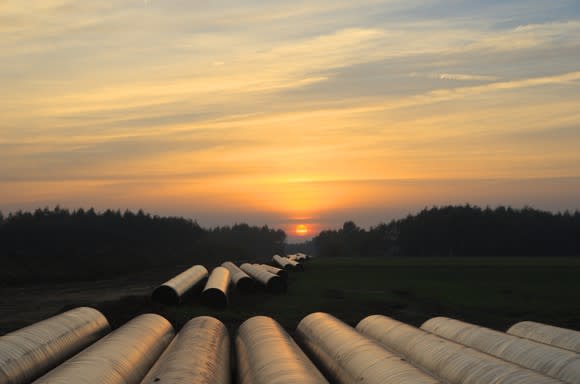 Pipelines laid out for construction at sunset.