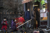 Residents wear masks and line up to enter a supermarket which is controlling the numbers of shoppers in Beijing, China on Tuesday, Feb. 25, 2020. The new virus took aim at a broadening swath of the globe Monday, with officials in Europe and the Middle East scrambling to limit the spread of an outbreak that showed signs of stabilizing at its Chinese epicenter but posed new threats far beyond. (AP Photo/Ng Han Guan)