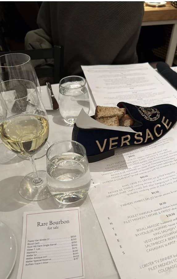 A bread basket in the shape of a shoe with "Versace" on it on a restaurant table