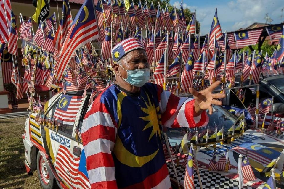 Taza says he spends hundreds of ringgit to change tattered flags every year. — Picture by Farhan Najib