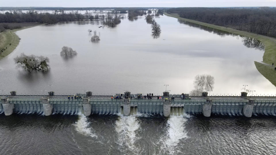 The Pretzien weir is pulled to ensure that a third of the Elbe water flows into a 21-kilometre-long canal around Schönebeck, Magdeburg and other places in the Elbe lowlands until it flows back into the Elbe, in Pretzien, Germany, Thursday Dec. 28, 2023. The approximately 135-metre-long weir was last opened in June 2013.(Simon Kremer/dpa via AP)