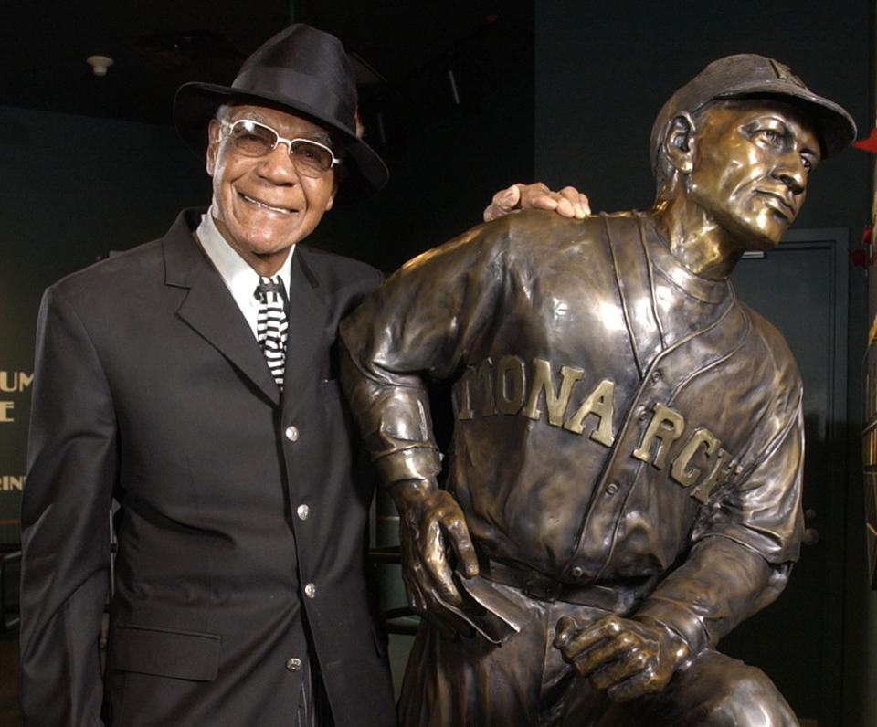 FILE - In this Feb. 11, 2005, file photo, Buck O'Neil stands with a statue of himself in the Negro League Baseball Museum in Kansas City, Mo. O’Neil, a champion of Black ballplayers during a monumental, eight-decade career on and off the field, has joined Gil Hodges, Minnie Minoso and three others in being elected to the baseball Hall of Fame, on Sunday, Dec. 5, 2021. (AP Photo/Charlie Riedel, File)