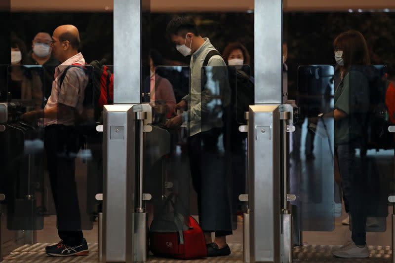 Passengers wearing masks go thotugh a security check point at Kuala Lumpur International Airport 2 in Sepang