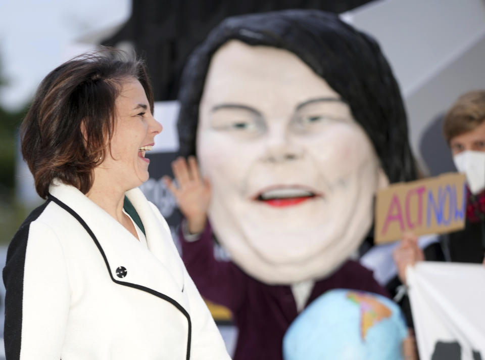 Annalena Baerbock, federal leader of the Green Party arrives at the venue for exploratory talks between the SPD, FDP and Greens on the formation of a new federal government after the Bundestag elections in Berlin, Germany, Friday, Oct. 15, 2021. She will be welcomed by Fridays for Future activists campaigning for tougher climate policies. The SPD, the Greens and the FDP want to agree on a decision-making basis for coalition negotiations that summarises the outcome of the negotiations so far. (Kay Nietfeld/dpa via AP)