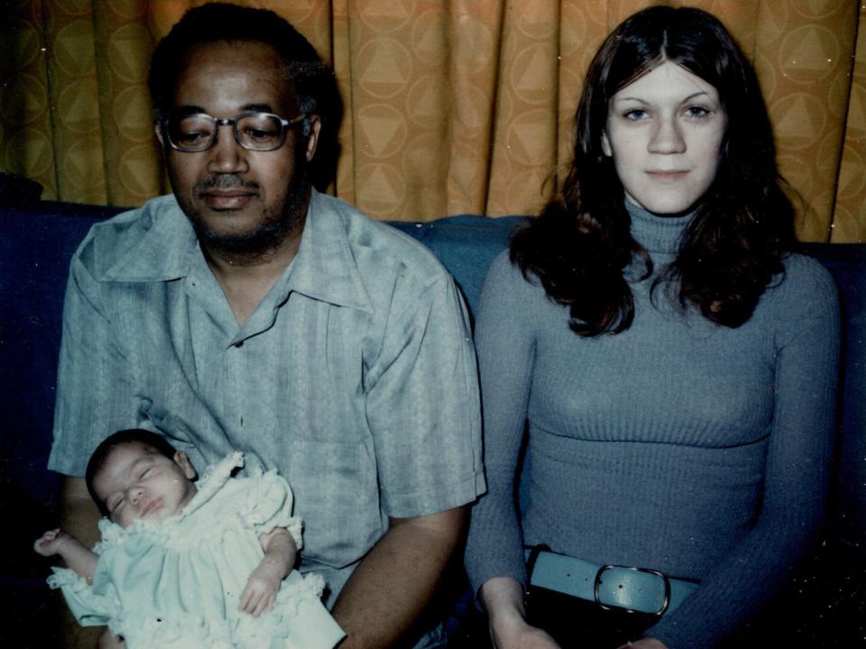 Kara Rubinstein Deyerin's grandfather, whom she called Pop, holds her in his arms as a baby. He is sitting on a sofa next to his then daughter-in-law Joey.