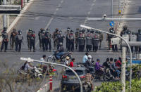 In this Feb. 27, 2021, file photo, police stand in formation blocking a main road from protesters in Mandalay, Myanmar. Myanmar's security forces have killed scores of demonstrators protesting a coup. The outside world has responded so far with tough words, a smattering of sanctions and little else. (AP Photo, File)