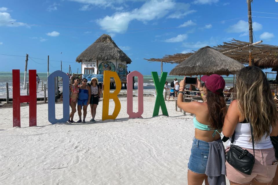 Tourists pose for a picture in Holbox Island, Mexico, on March 7, 2021. Holbox is famous for its large congregation of whale sharks and as ideal destination for nature lovers.