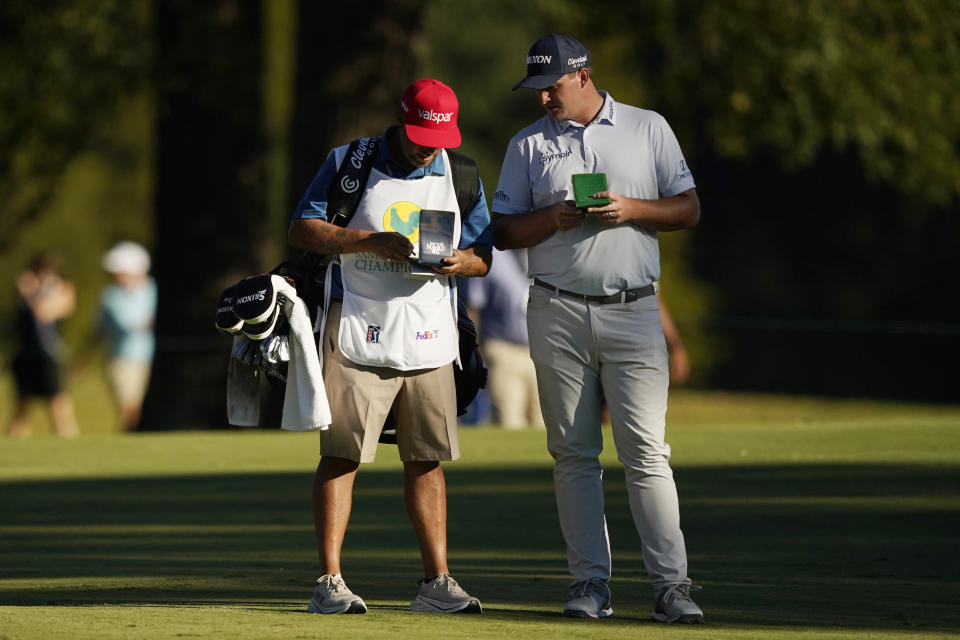 Sepp Straka, of Austria, compares notes with his caddie prior to hitting from the 18th fairway during the second round of the Sanderson Farms Championship golf tournament in Jackson, Miss., Friday, Sept. 30, 2022. (AP Photo/Rogelio V. Solis)