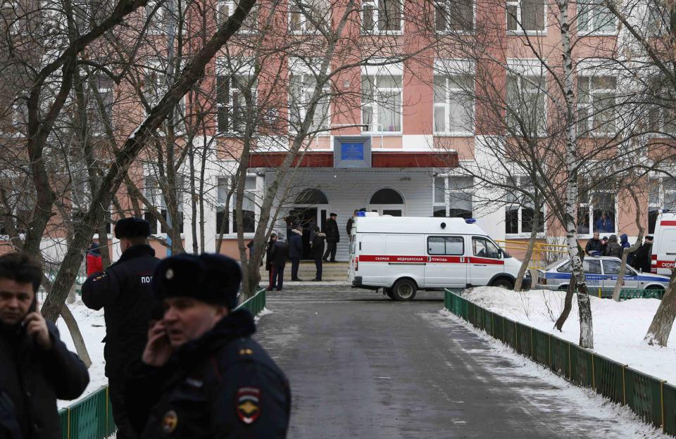 Interior Ministry members and other authorities gather outside a high school on the outskirts of Moscow