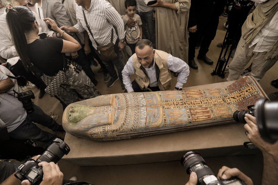 Mostafa Waziri, secretary-general of the Supreme Council of Antiquities, displays a recently unearthed ancient wooden sarcophagus at the site of the Step Pyramid of Djoser in Saqqara, 24 kilometers (15 miles) southwest of Cairo, Egypt, Saturday, May 27, 2023. Saqqara is a part of Egypt's ancient capital of Memphis, a UNESCO World Heritage site. Waziri said the workshops had been used to mummify humans and sacred animals, dated back to the 30th Pharaonic Dynasty 380 BC to 343 BC and Ptolemaic period 305 BC to 30 BC. (AP Photo/Amr Nabil)