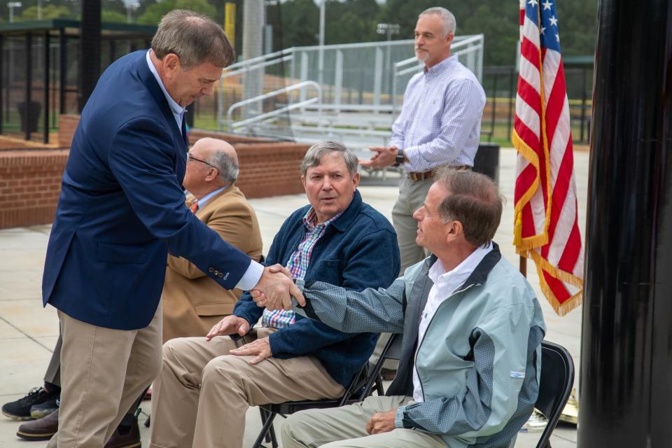 Gadsden Mayor Craig Ford greets his predecessor, Sherman Guyton, during a ceremony Monday officially opening Phase II of the Gadsden Sports Complex. Seated next to Guyton, from left, are City Council President Kent Back and Frankie Davis, the city's former director of economic development. Standing is Heath Williamson, the city's director of engineer.