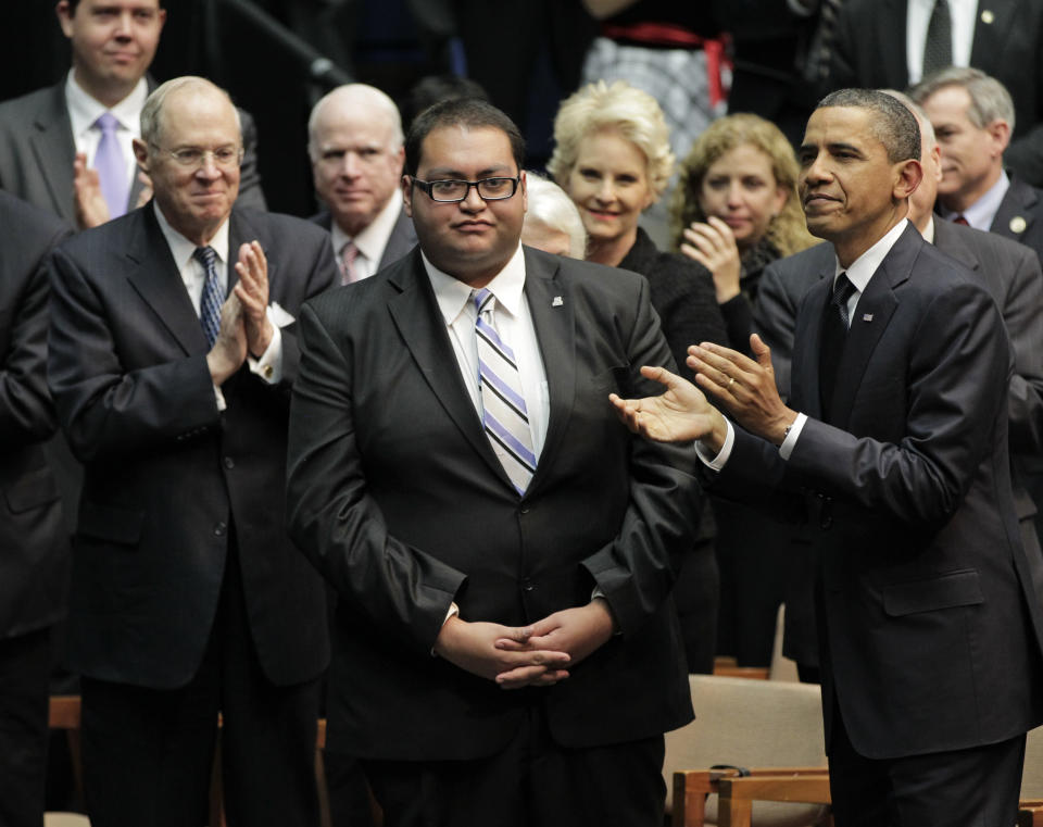 FILE - In this Jan. 12, 2011 file photo, Daniel Hernandez Jr., center, who was with Rep. Gabrielle Giffords when she was shot, receives a standing ovation, during President Obama's visit to speak in Tucson, Ariz., in the wake of the mass shooting. Hernandez Jr., announced Thursday, May 20, 2021, he's running to represent Giffords former district in Congress. (AP Photo/J. Scott Applewhite, File)