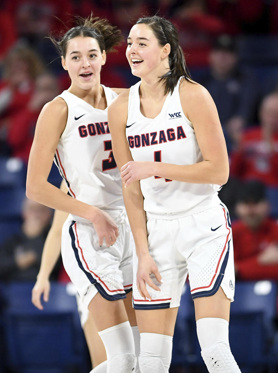 In this Jan. 9, 2020 photo, Gonzaga forwards LeeAnne Wirth (4) and Jenn Wirth (3), twin sisters, laugh between during the first half of an NCAA college basketball game in Spokane, Wash. (Tyler Tjomsland/The Spokesman-Review via AP)