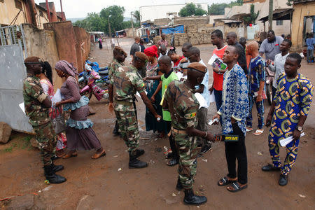 Malian soldiers carry out checks as people wait at a polling station before the polls open during a presidential run-off election in Bamako, Mali August 12, 2018. REUTERS/Luc Gnago