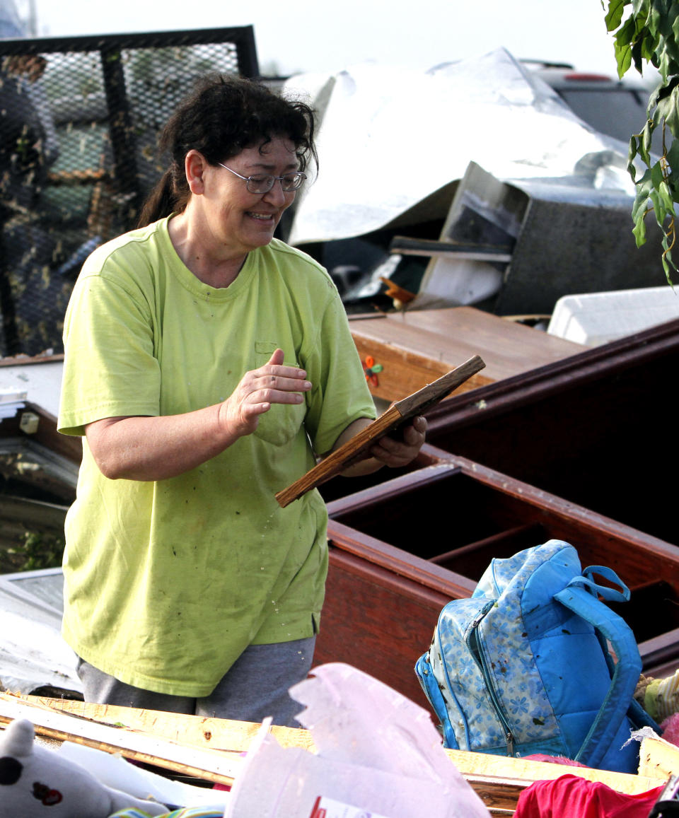 Teresa Ingram finds a picture of her daughter as she looks for belongings in the debris after a tornado passed through destroying Billy Barbs mobile home park on Tuesday, April 29, 2014, in Athens, Ala. A dangerous storm system that spawned a chain of deadly tornadoes killed dozens from the Midwest to the Deep South. (AP Photo/Butch Dill)