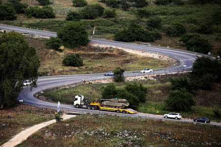 A tank can be seen on a lorry as it drives on a road near the Israeli side of the border with Syria in the Israeli-occupied Golan Heights, Israel May 9, 2018. REUTERS/Amir Cohen