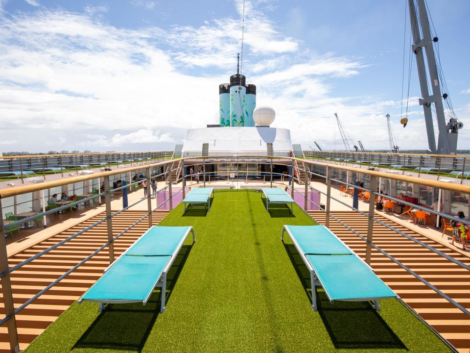 Lounge chairs on a patch of fake grass.