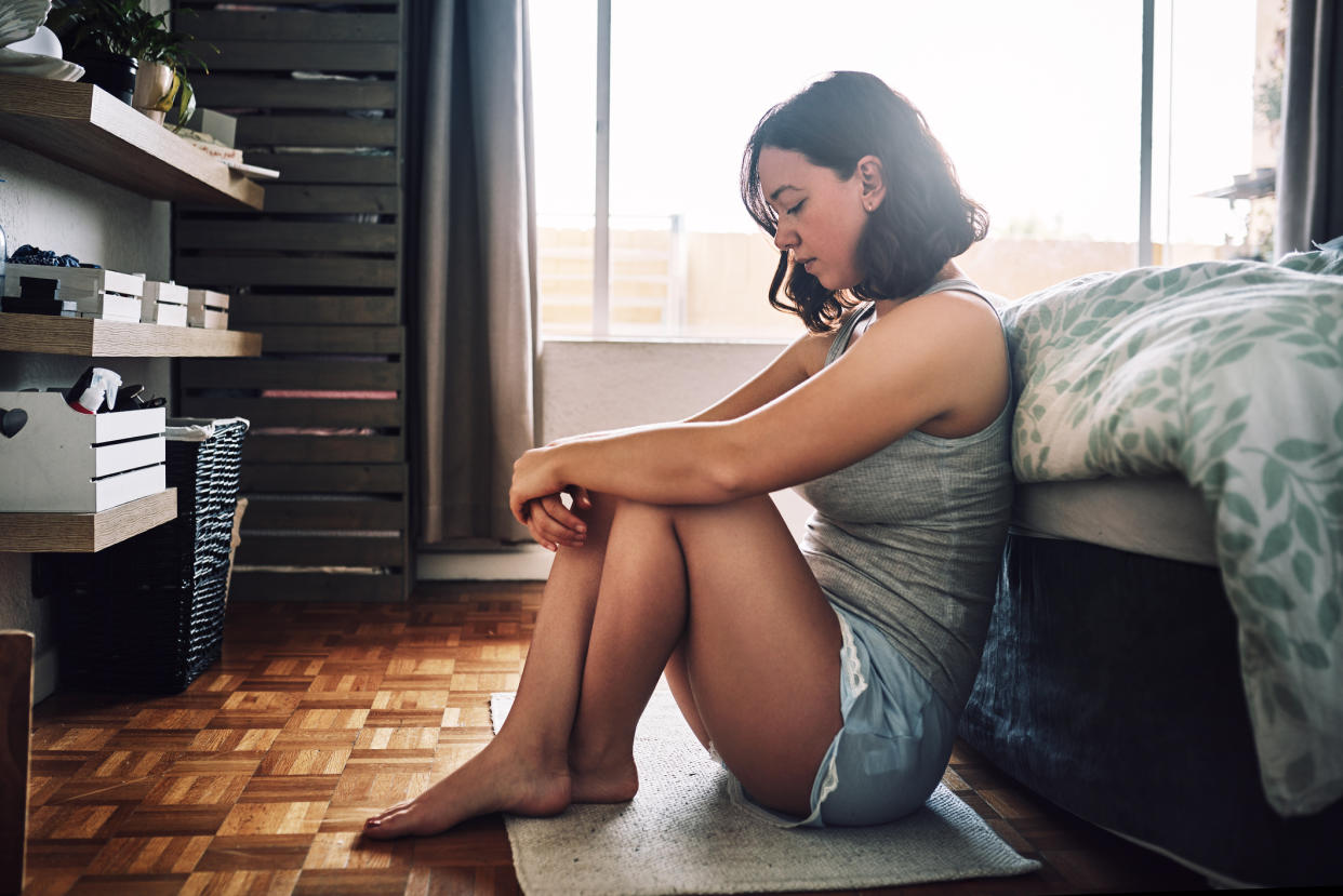 Woman feeling sad in her bedroom. (Getty Images)