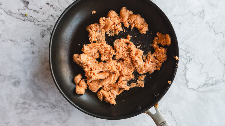 Uncooked sausage in pan