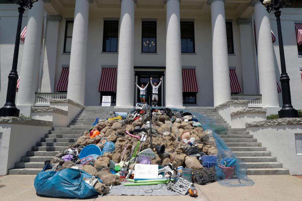 Plastic Symptoms Co-Founders Heather Bolint and Bryan Galvin stand atop the steps of the Florida Historic Capitol after two hours of unloading nearly 3,000 pounds of garbage the pair collected from the ocean along Florida's coastline onto the steps. They brought the load to the Capitol Monday, July 29, 2019, to bring awareness to the harms of single-use plastics.