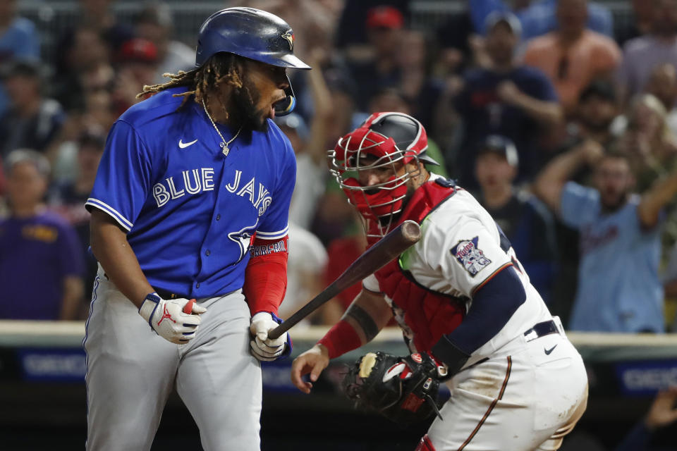 Toronto Blue Jays' Vladimir Guerrero reacts to striking out as Minnesota Twins catcher Sandy Leon, right, applies the tag, to end the baseball game Saturday, Aug. 6, 2022, in Minneapolis. The Twins won 7-3. (AP Photo/Bruce Kluckhohn)