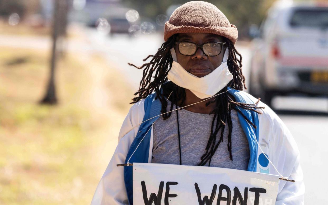 Zimbabwean novelist Tsitsi Dangarembga holds a placard during an anti-corruption protest march along Borrowdale road, on July 31, 2020 in Harare - AFP