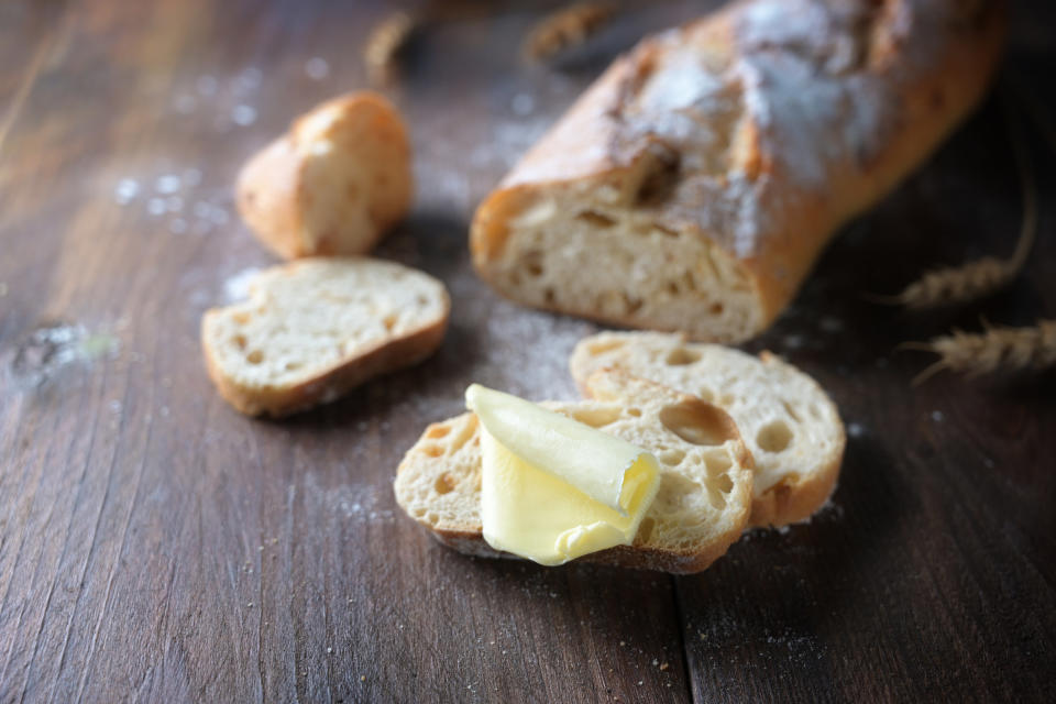 Sliced French bread with a piece of butter.