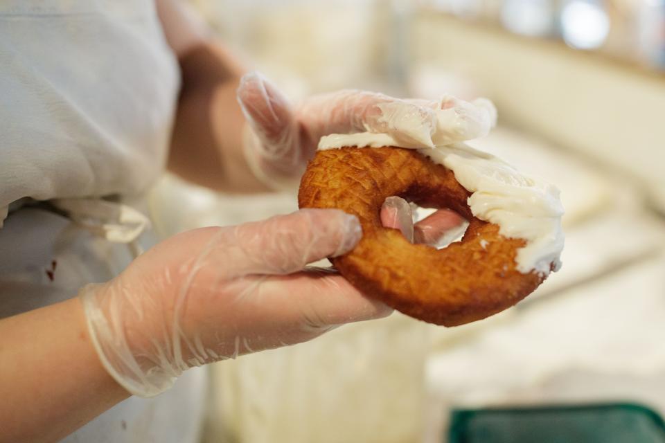 Crystal Leduc, a former nurse turned SōDOUGH Baking Co. owner, frosts a donut Thursday, Feb. 3, 2022.