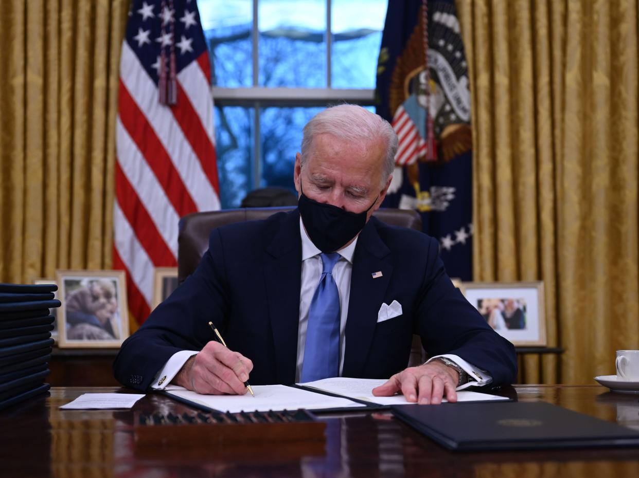 Joe Biden signs his first executive orders after being sworn in as US president (AFP via Getty Images)