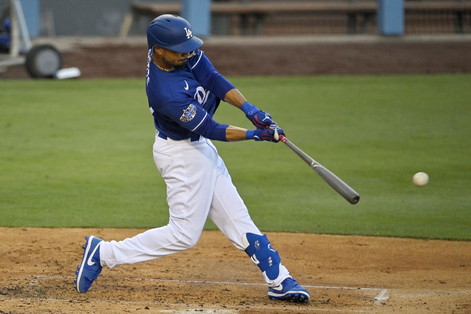 FILE - In this July 6, 2020, file photo, Los Angeles Dodgers' Mookie Betts hits during intrasquad play in the restart of baseball spring training in Los Angeles. The Dodgers open the season at home on July 23 with a four-game series against the rival San Francisco Giants. (AP Photo/Mark J. Terrill, File)