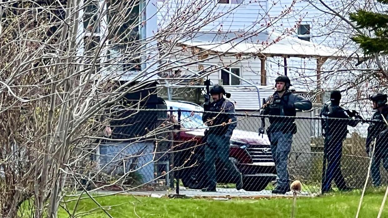 Officers could be seen around a residence on Gaston Road on Tuesday wearing body armour and carrying long guns. (Jean Laroche/CBC - image credit)