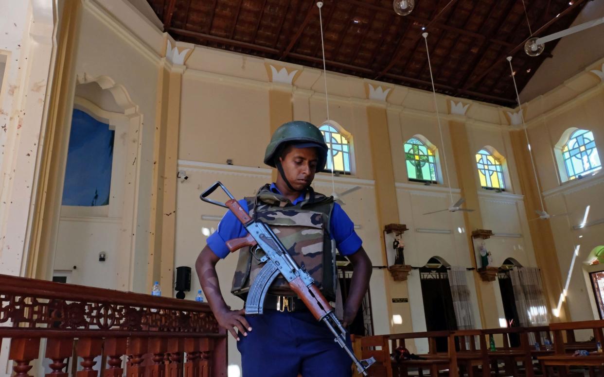 A police officer stands guard in Katuwapitiya St. Sebastian church in Negombo near Colombo - REX