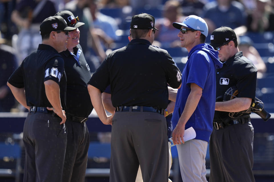 Chicago Cubs manager Craig Counsell, second from right, talks with umpires, from left, David Arrieta, Bill Miller, Doug Eddings, and Tyler Jones, before a spring training baseball game against the Milwaukee Brewers, Wednesday, Feb. 28, 2024, in Phoenix, Ariz. (AP Photo/Carolyn Kaster)