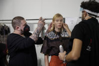 A model gets her make-up done in the backstage prior to the start of the Shi.RT women's Spring-Summer 2021 fashion show, in Milan, Italy, Sunday, Sept. 27, 2020. (AP Photo/Luca Bruno).