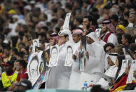Spectators hold portraits of former German player Mesut Ozil during the World Cup group E soccer match between Spain and Germany, at the Al Bayt Stadium in Al Khor, Qatar, Sunday, Nov. 27, 2022. (AP Photo/Ebrahim Noroozi)