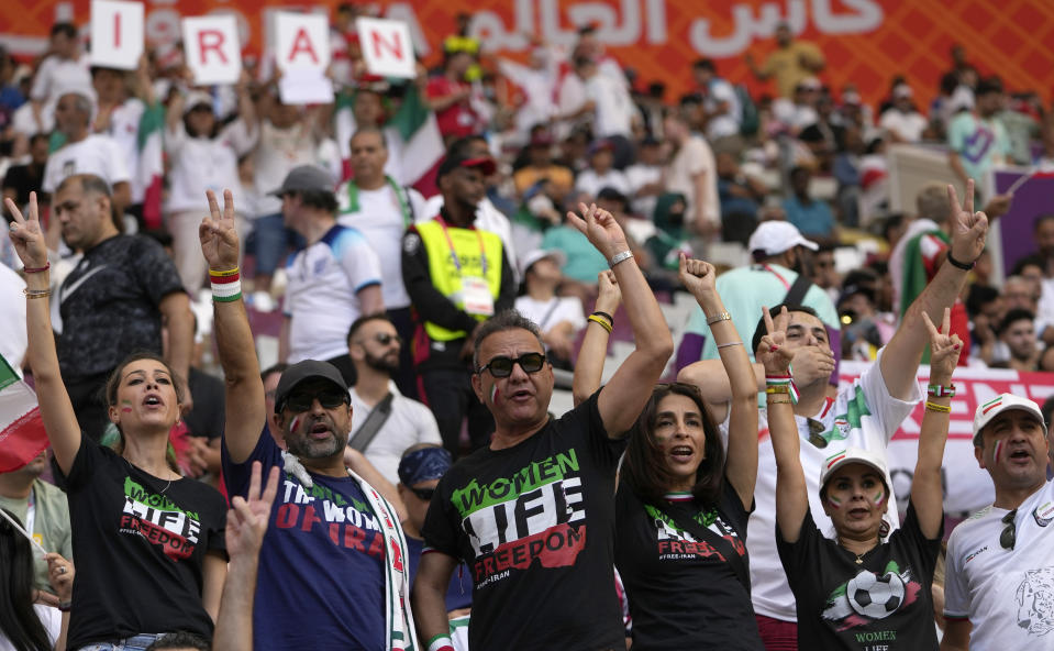 Iranian soccer fans shout slogan "Woman Life Freedom" prior to the World Cup group B soccer match between England and Iran at the Khalifa International Stadium in in Doha, Qatar, Monday, Nov. 21, 2022. (AP Photo/Alessandra Tarantino)