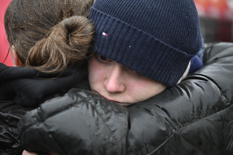Mourners hug in front of the building of Philosophical Faculty of Charles University in downtown Prague, Czech Republic, Saturday, Dec. 23, 2023. A lone gunman opened fire at a university on Thursday, killing more than a dozen people and injuring scores of people. (AP Photo/Denes Erdos)