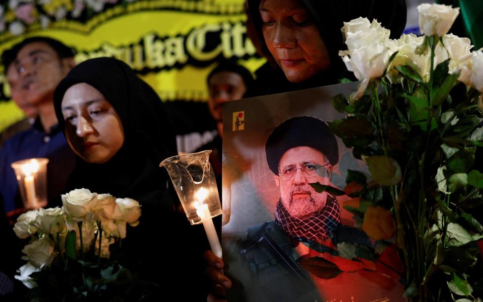 A woman holding a picture of Raisi at a vigil in Jakarta, Indonesia.