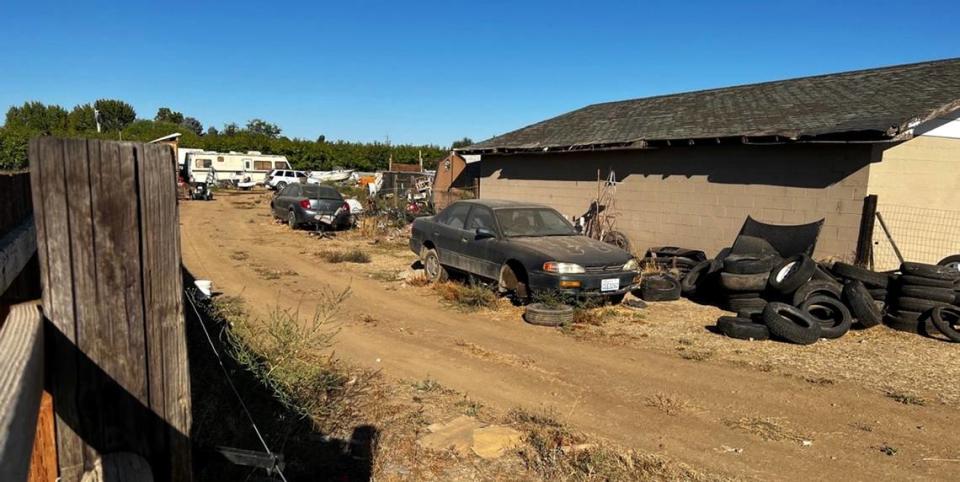 A broken down car and piles of tires are seen in this photo of a property at the center of dozens of 911 and code enforcement calls in Benton County.