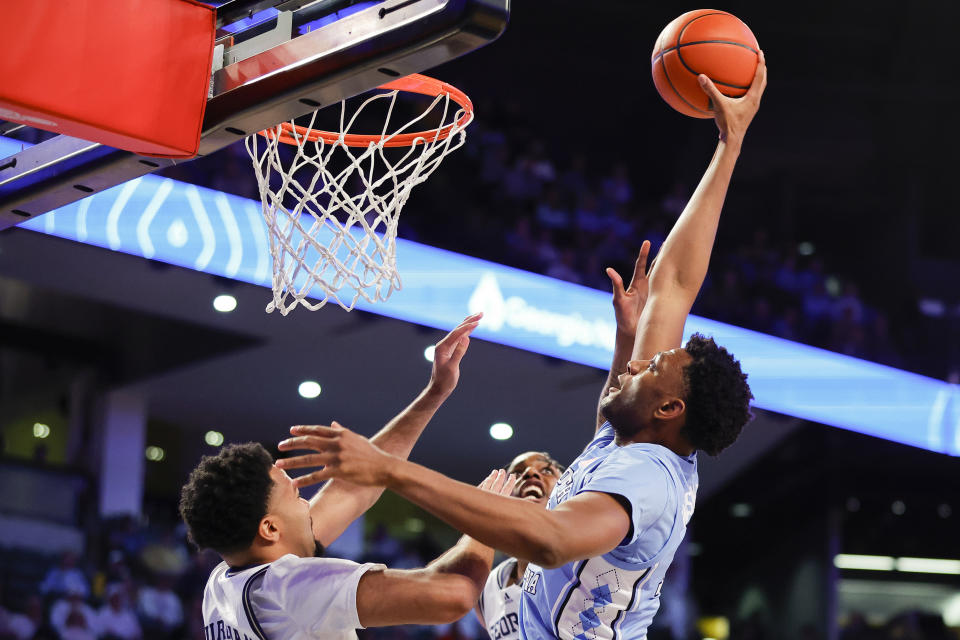 North Carolina forward Jalen Washington, right, slam dunks the ball over Georgia Tech guard Kyle Sturdivant, left, during the first half of an NCAA college basketball game Tuesday, Jan. 30, 2024, in Atlanta. (AP Photo/Alex Slitz)