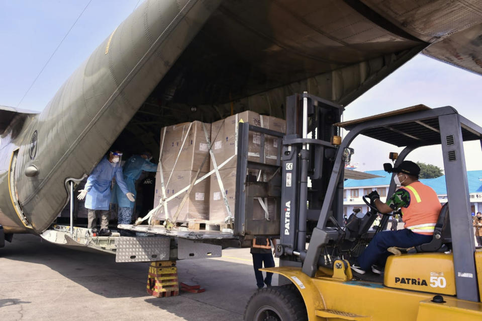 In this photo released by Indonesian Armed Forces, a military personnel uses a forklift to unload relief goods from a Singaporean Air Force cargo plane at Halim Perdanakusuma Airbase in Jakarta, Indonesia, Friday, July 9, 2021. The world's fourth most populous country is running out of oxygen as it endures a devastating wave of coronavirus cases and the government is seeking emergency supplies from other countries, including Singapore and China. (Indonesian Armed Forces via AP)