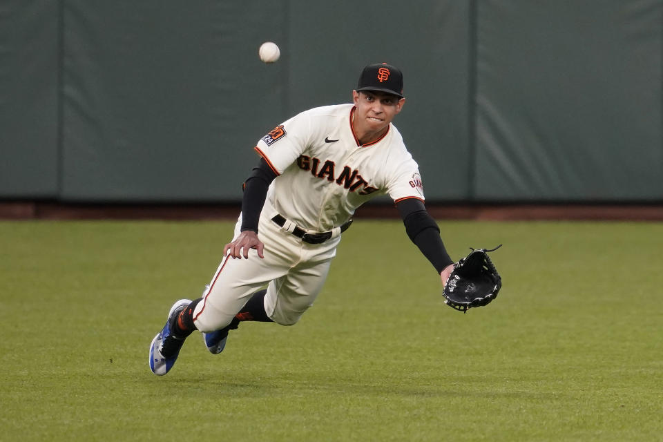 San Francisco Giants center fielder Mauricio Dubon cannot catch a base hit by Seattle Mariners' Dylan Moore during the first inning of a baseball game in San Francisco, Wednesday, Sept. 16, 2020. This is a makeup of a game postponed Tuesday in Seattle. (AP Photo/Jeff Chiu)