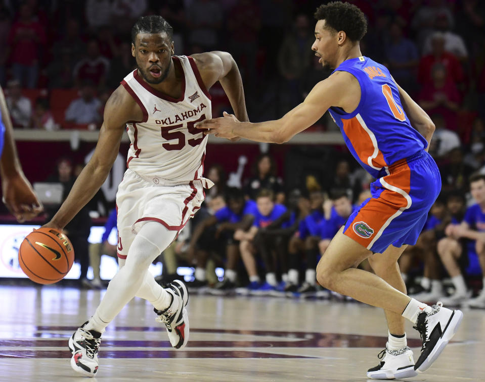 Oklahoma guard Elijah Harkless (55) pushes past Florida guard Myreon Jones (0) during the second half of an NCAA college basketball game in Norman, Okla., Wednesday, Dec. 1, 2021. (AP Photo/Kyle Phillips)