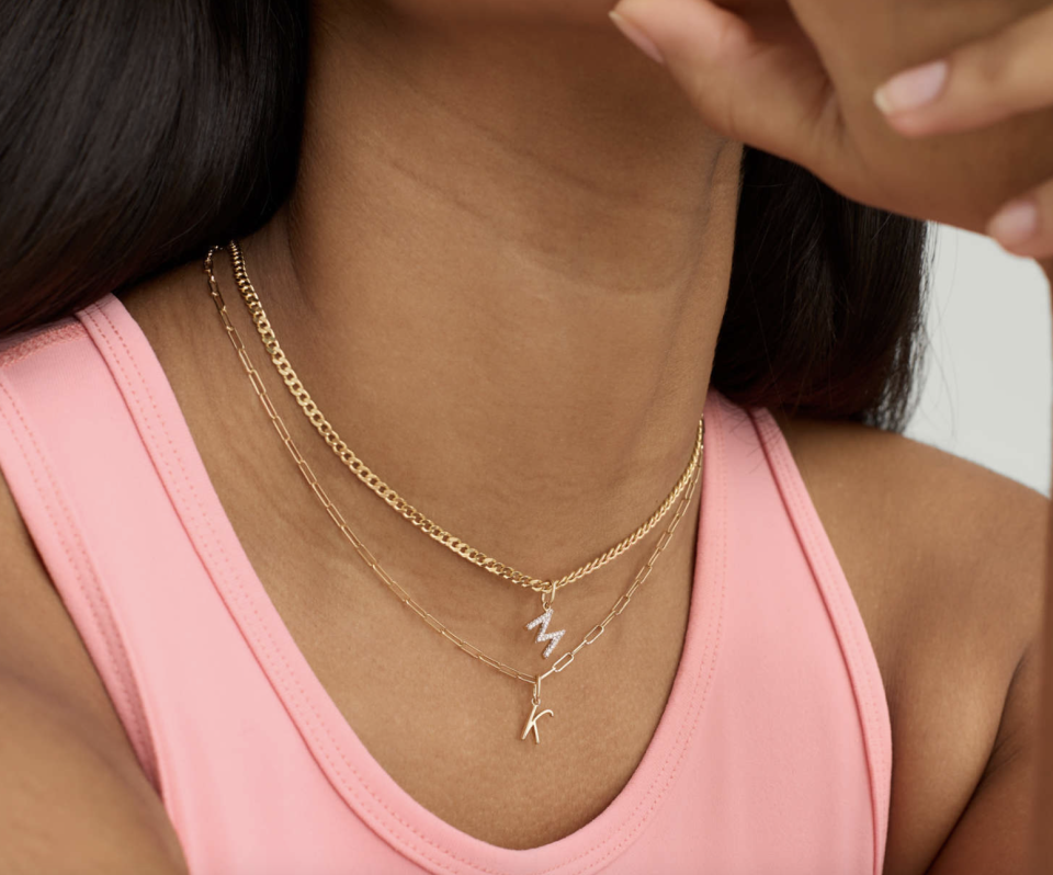 woman wearing pink tank top and gold necklace with Diamond Letter Charm (Photo via Mejuri)