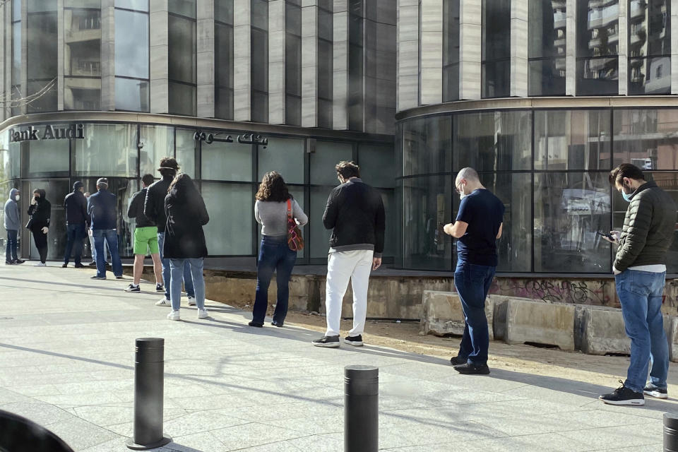 Personas haciendo cola frente a un banco de Beirut el 28 de marzo del 2020. El gobierno libanés puso límites a la cantidad de dólares que la gente puede retirar o transferir en medio de una crisis económica sin precedentes. (AP Photo/Zeina Karam, File)