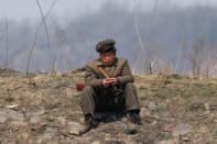 A North Korean soldier sits on a bank of the Yalu River just north of Sinuiju, North Korea, April 2, 2017. REUTERS/Damir Sagolj