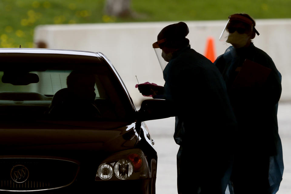 In this Friday, May 1, 2020, photo, medical workers test a local resident at a drive-thru COVID-19 testing site in Waterloo, Iowa. The coronavirus is devastating the nation’s meatpacking communities — places like Waterloo and Sioux City in Iowa, Grand Island, Neb., and Worthington, Minn. Within weeks, the outbreaks around slaughterhouses have turned into full-scale disasters. (AP Photo/Charlie Neibergall)